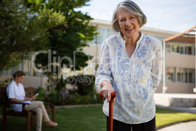 Portrait of smiling senior woman with doctor in background