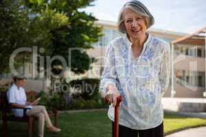 Portrait of smiling senior woman with doctor in background