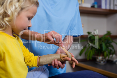 Female physiotherapist giving hand massage to girl patient