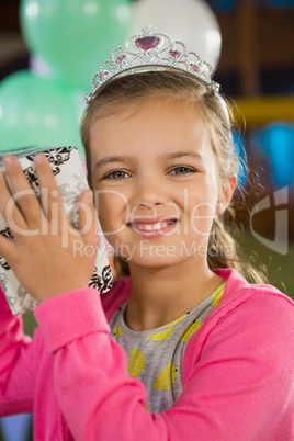 Birthday girl holding a gift box at home