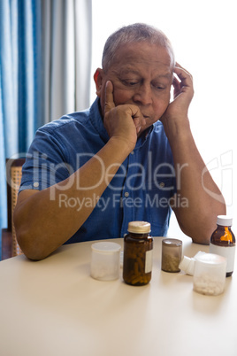 Thoughtful senior man looking at medicines