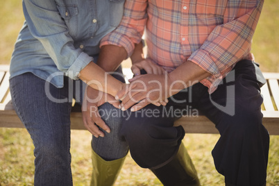 Senior couple holding each others hand while sitting on a bench