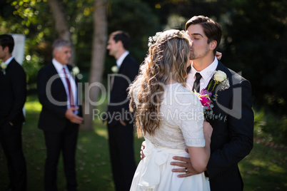 Affectionate groom kissing bride on forehead