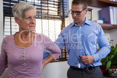 Physiotherapist examining a female patients back