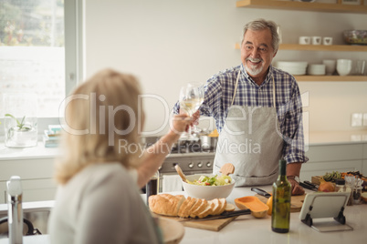 Senior couple toasting wine glasses