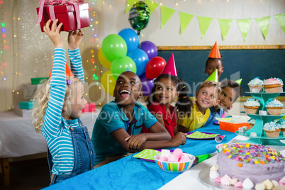 Children looking at girl holding gift