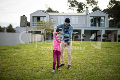 Father and daughter dancing in garden