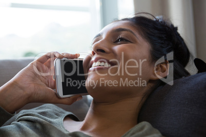 Smiling woman talking on phone at home