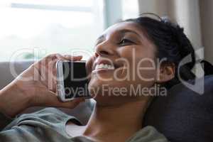 Smiling woman talking on phone at home