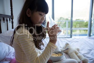 Girl having breakfast on bed