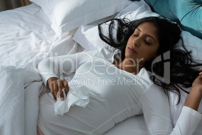Sick young woman sleeping on bed