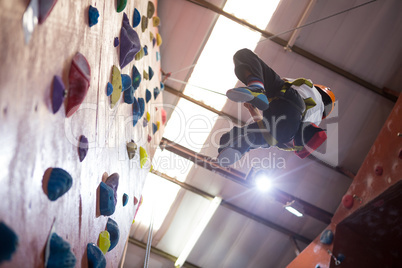 Determined boy practicing rock climbing