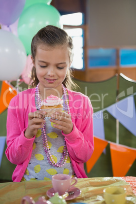 Birthday girl holding a cupcake