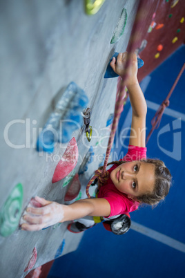 Determined teenage girl practicing rock climbing