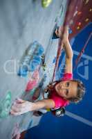 Determined teenage girl practicing rock climbing