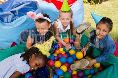 Female friends by boy in ball pool