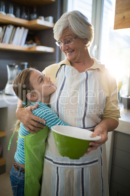 Grandmother and granddaughter embracing in the kitchen