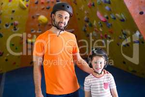 Portrait of trainer and kids standing in fitness studio