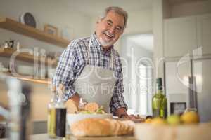 Senior man chopping vegetables at home