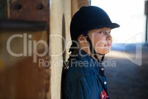 Girl leaning on wall in the stable