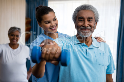 Nurse guiding senior man in exercising