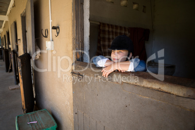 Girl leaning on wall in the stable