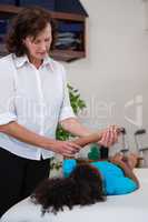 Physiotherapist giving hand massage to a girl patient