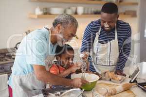 Boy learning to whisk the eggs while preparing cookies