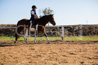 Boy riding a horse in the ranch