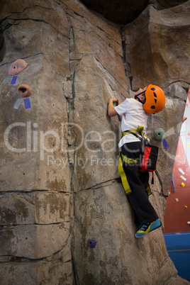 Determined boy practicing rock climbing