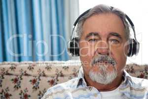 Close up portrait of senior man wearing headphones in nursing home