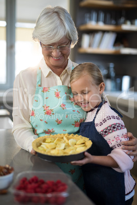 Grandmother and granddaughter looking at fresh cut apples on crust