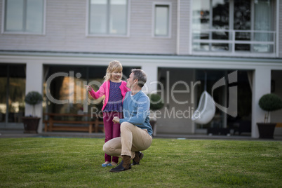 Father and daughter interacting with each other in garden