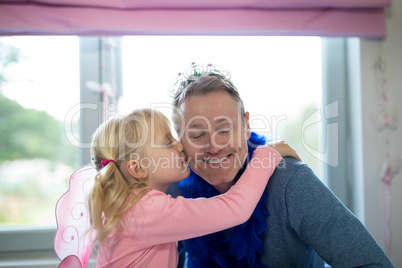 Girl dressed as fairy kissing her father