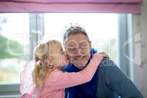 Girl dressed as fairy kissing her father