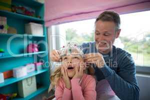 Father putting a tiera on daughters head