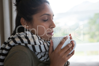 Woman with eyes closed holding coffee cup