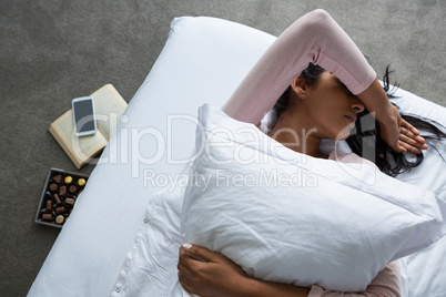 Woman lying down on bed over floor