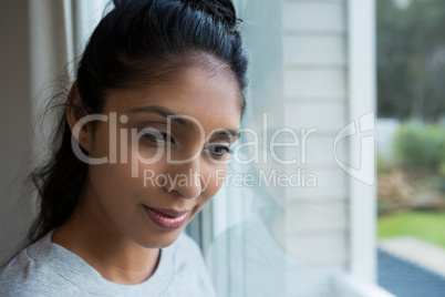 Thoughtful woman by glass window