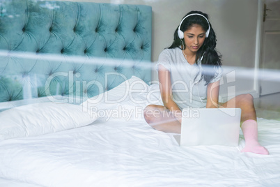 Woman listening to music while using laptop