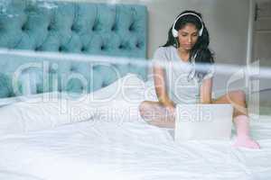 Woman listening to music while using laptop