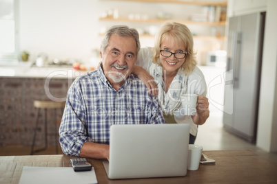 Senior couple using laptop at home