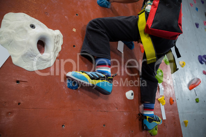 Boy practicing rock climbing in fitness studio