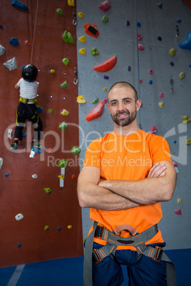 Trainer standing with arms crossed in fitness studio