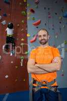 Trainer standing with arms crossed in fitness studio