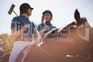 Two male jockeys riding horse in the ranch