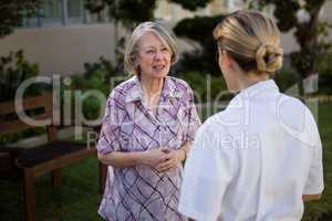 Senior woman and doctor talking in park