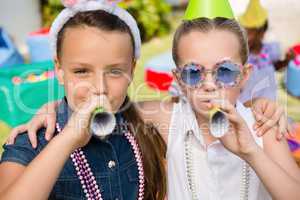 Close up portrait of girls blowing party horn