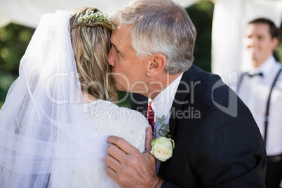 Affectionate father kissing his daughter