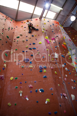 Determined boy practicing rock climbing